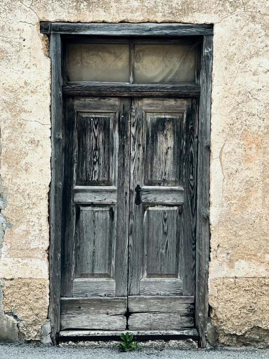 an old door on a stone building next to a road