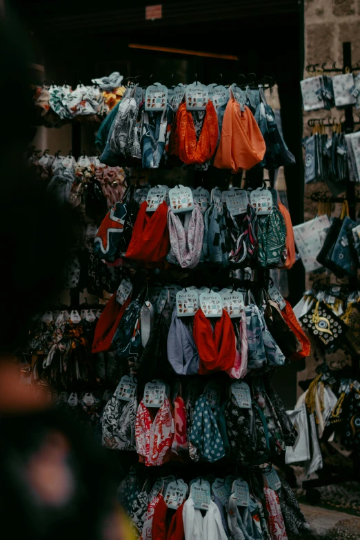 a display of women's clothes and t - shirts at an outdoor market