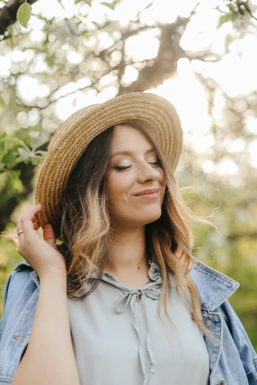 a woman wearing a hat is smiling while she looks up