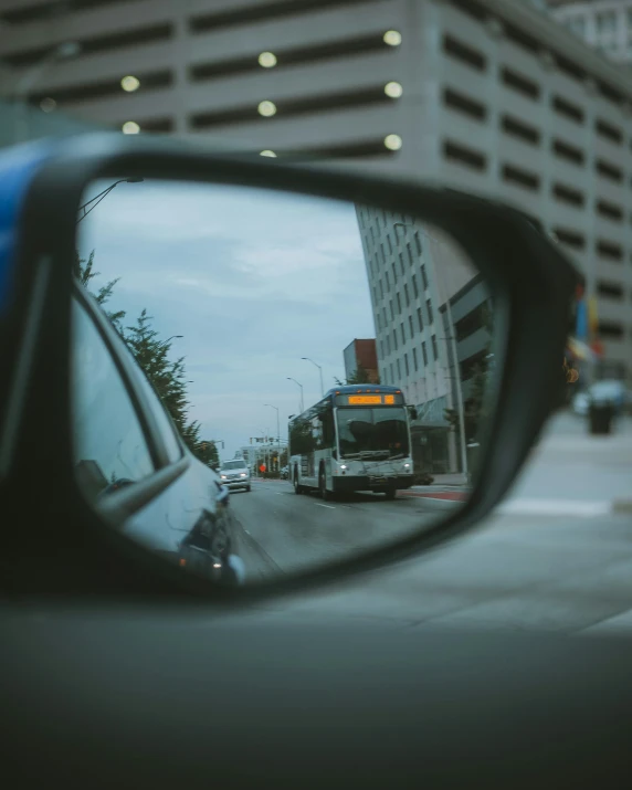 a truck reflected in a mirror next to a tall building