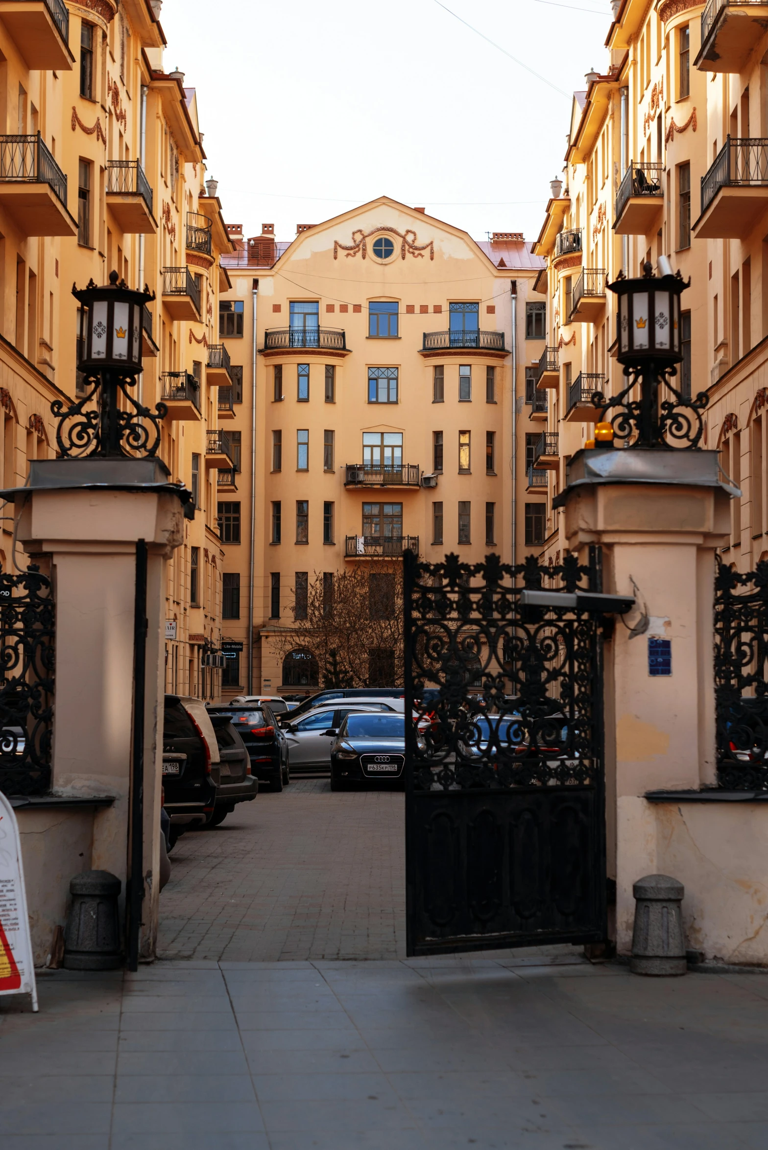 some buildings and cars on a street near a fence