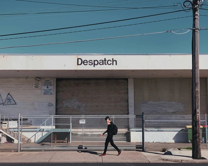 a person skateboarding on the street near a despatch building