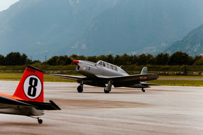 an old plane on the ground and another plane near by