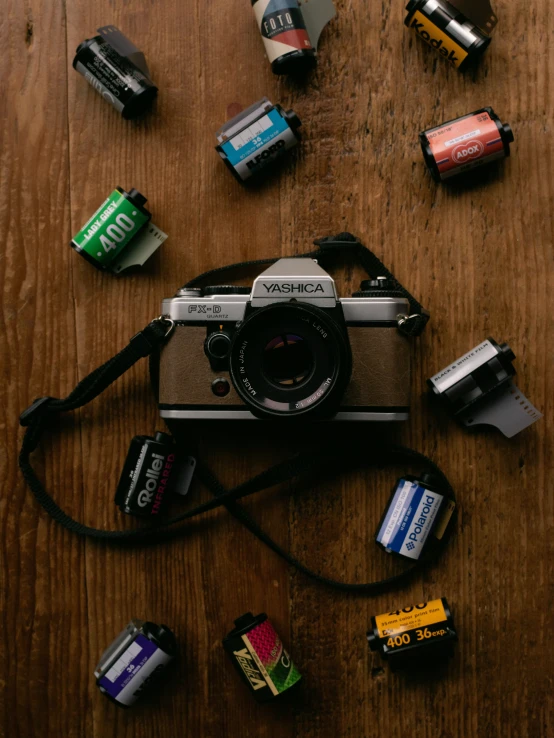 a po camera on a wooden surface with several batteries