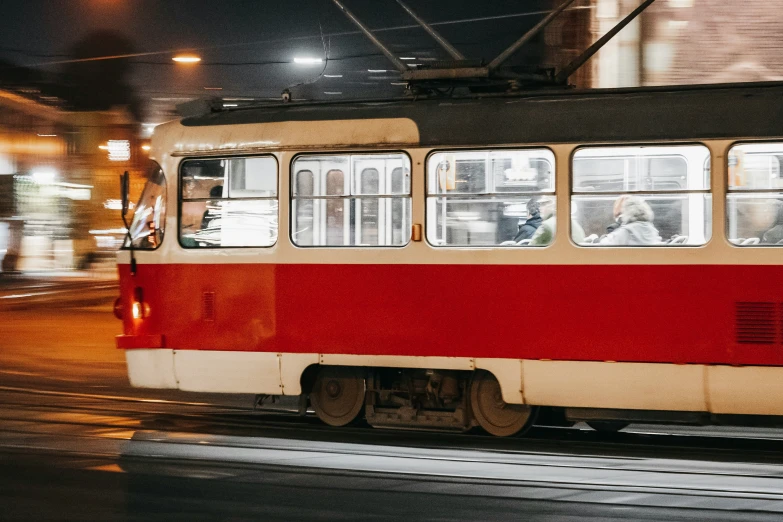 a red and white trolley sitting on top of a street