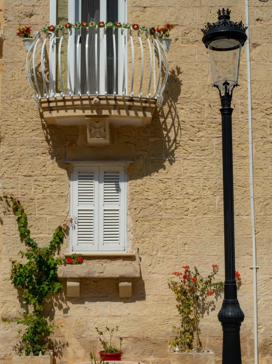 a balcony with flower box planters below and lamp