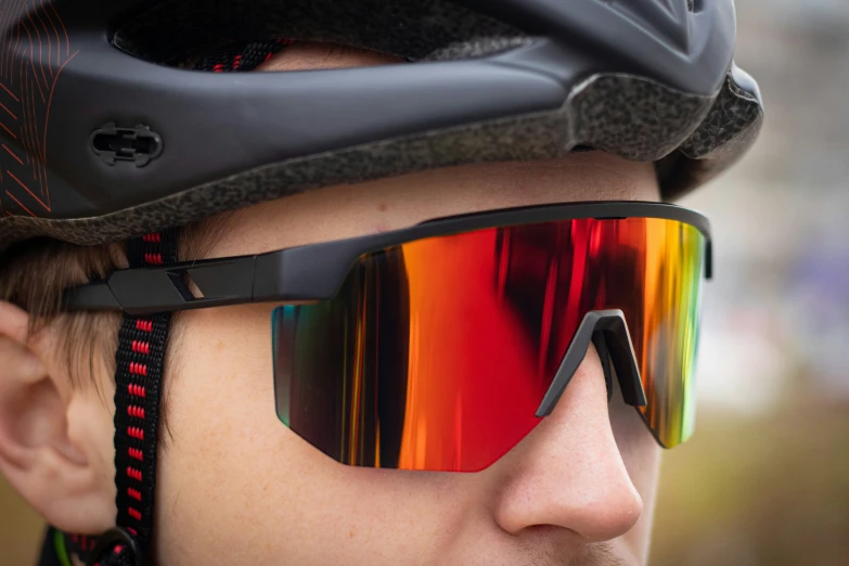 the side of a man's face wearing sunglasses with reflective gear