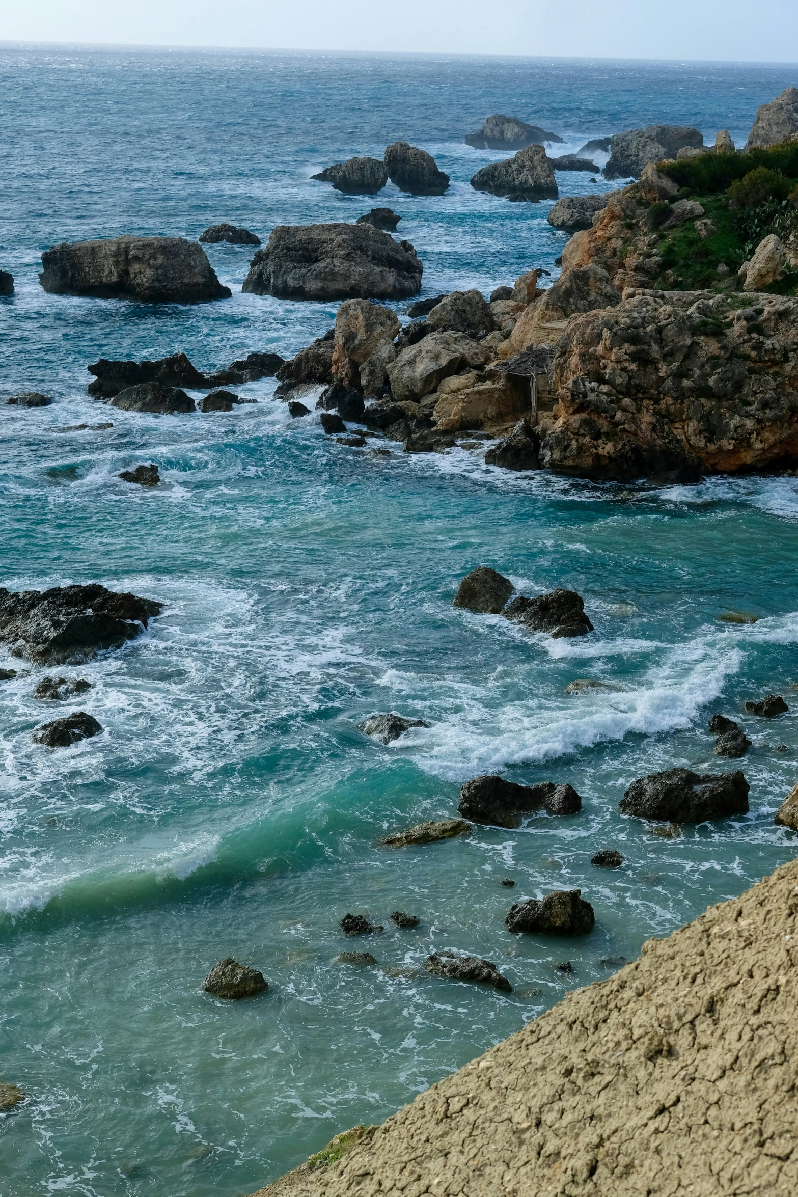 the view from the shore of an empty beach near some water