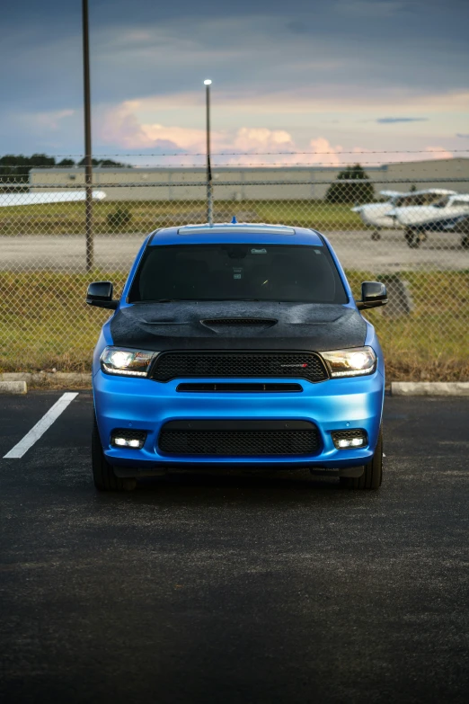 a bright blue muscle car parked in a parking lot