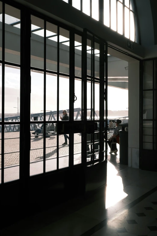 two men sitting at a table in the middle of a large window