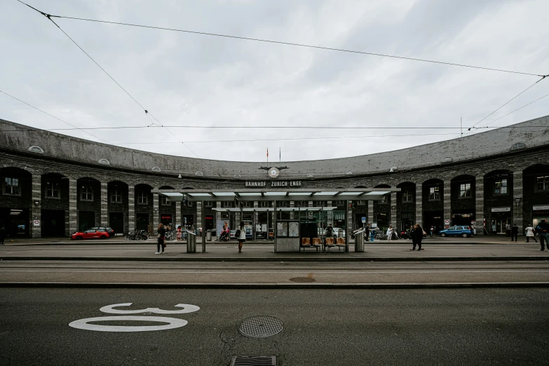 the outside of an airport with several people waiting