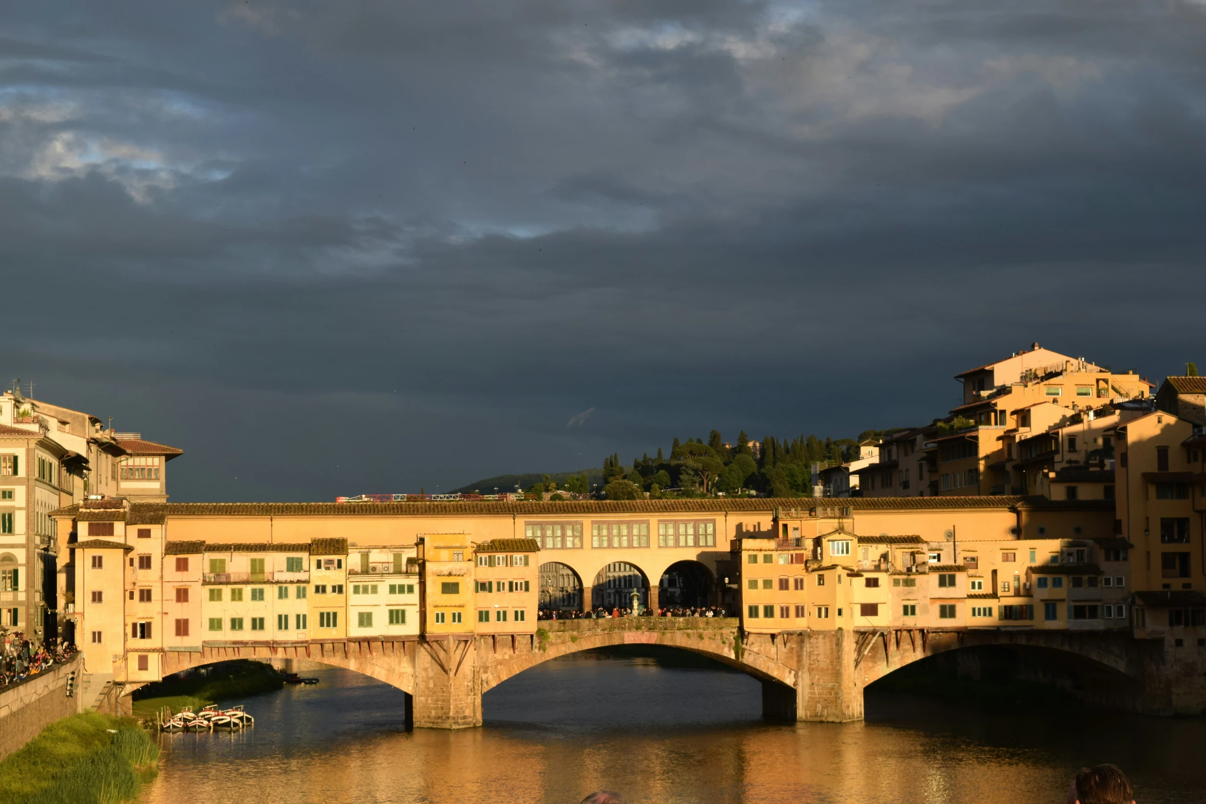 a river that has some boats going under a bridge