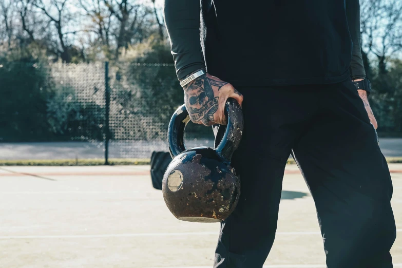 a close up of a tennis player holding a ball and a bag