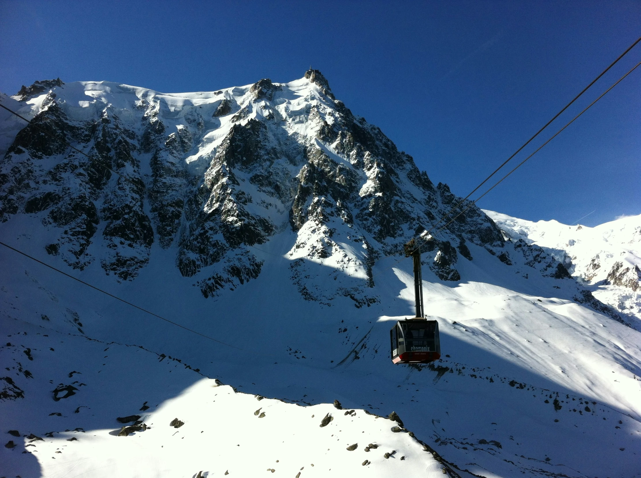 a snowy mountain covered in snow next to a ski lift