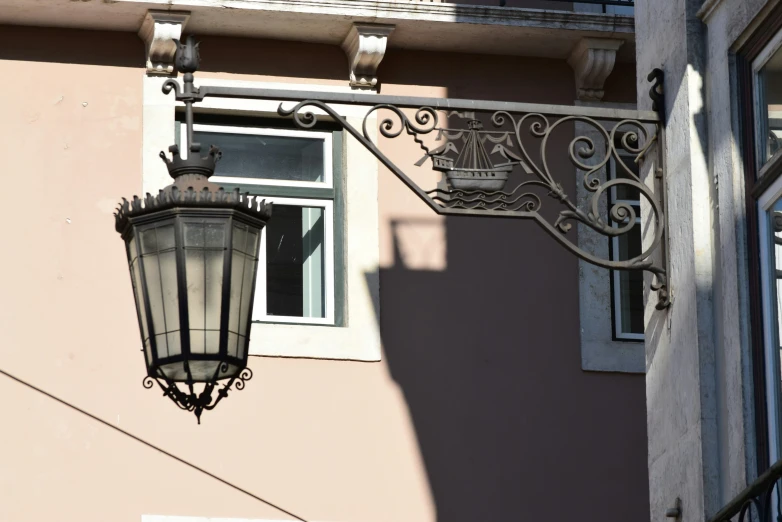 an old fashioned street light hangs outside of a building