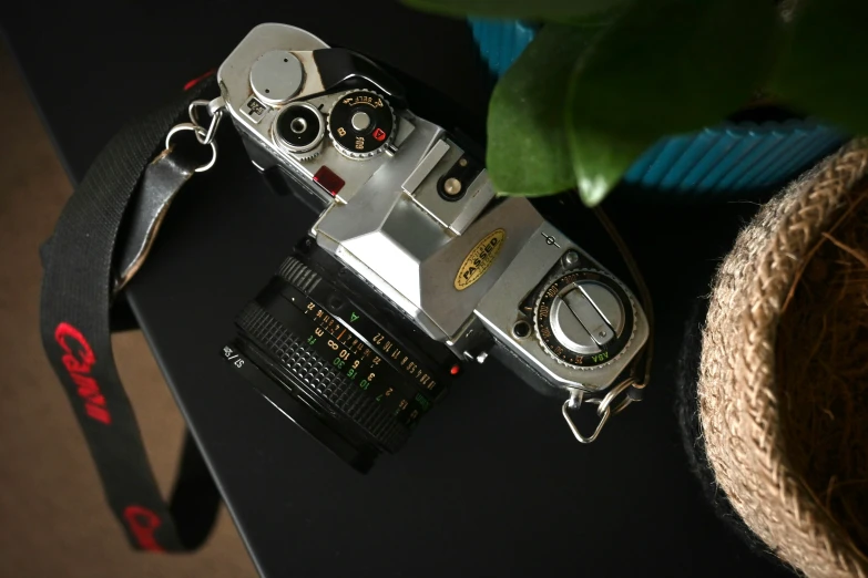 a po camera sits on a desk next to some rope