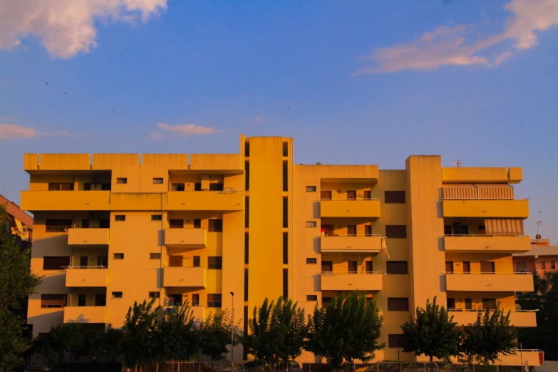 a couple of yellow buildings with balconies and cars on the street