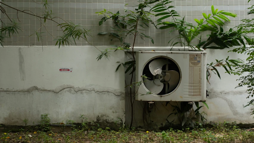 an old air conditioner next to a broken wall