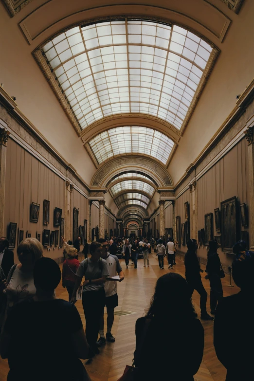 a large group of people walk in a huge building