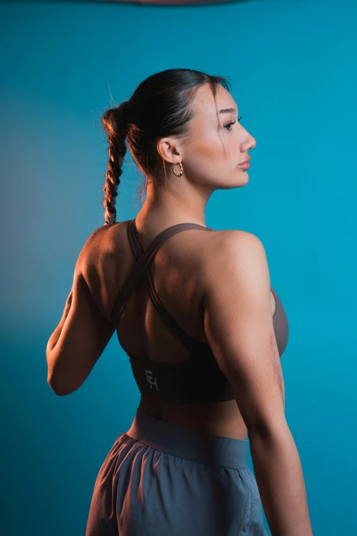 a woman standing in a yoga pose and showing her muscular arms