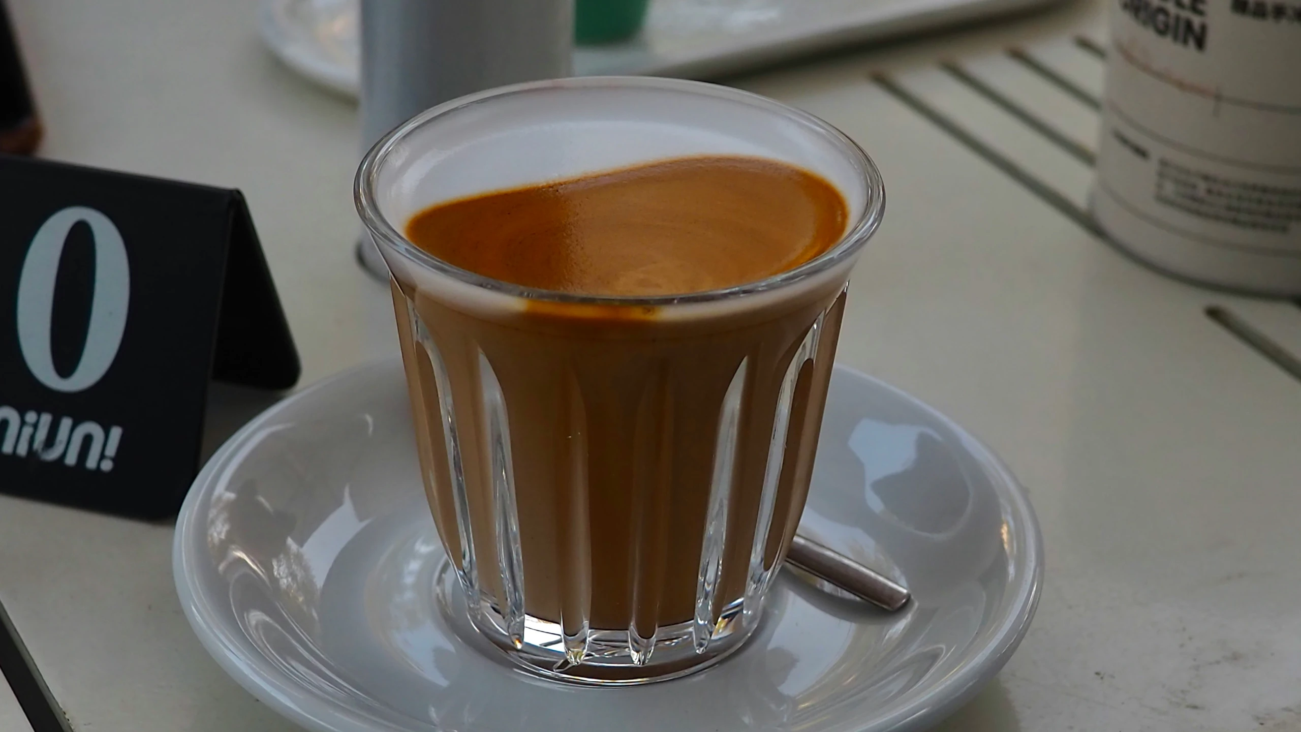 a small cup filled with liquid sitting on a plate