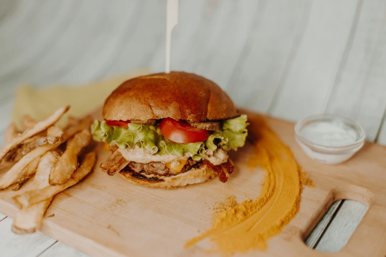 a meat sandwich with tomato, lettuce and some chips on the side