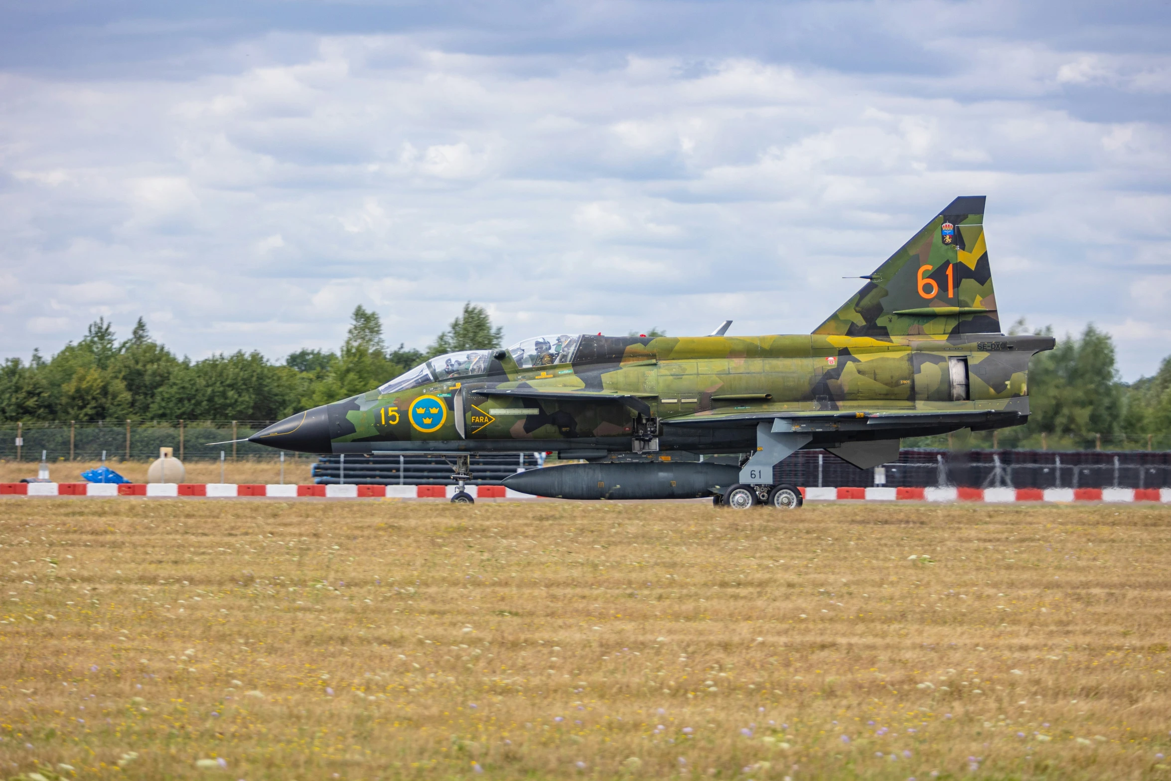 the jet airplane is parked in the middle of the field