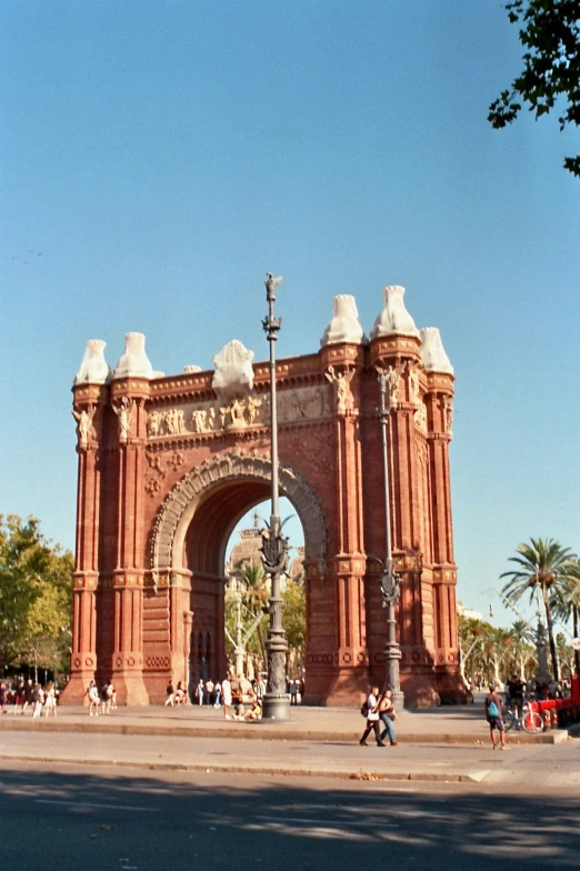 two people walking towards an arch with people walking in it