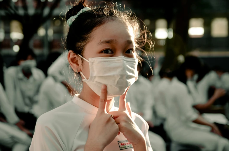 a young asian girl wears a protective face mask
