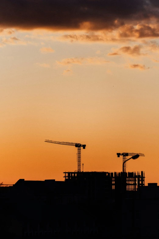 a building under construction with a crane at dusk