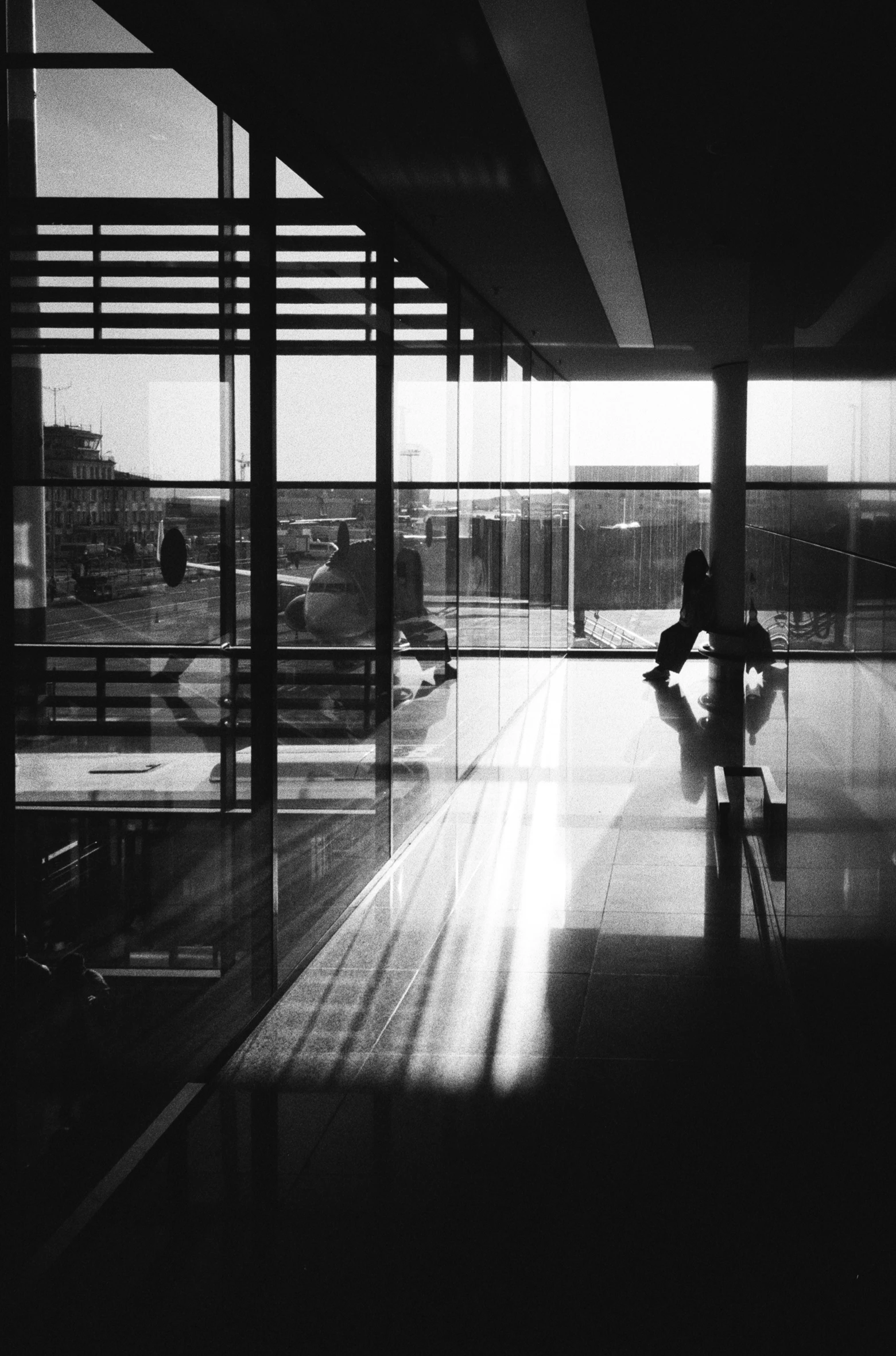 a person sitting on a bench in the middle of an airport