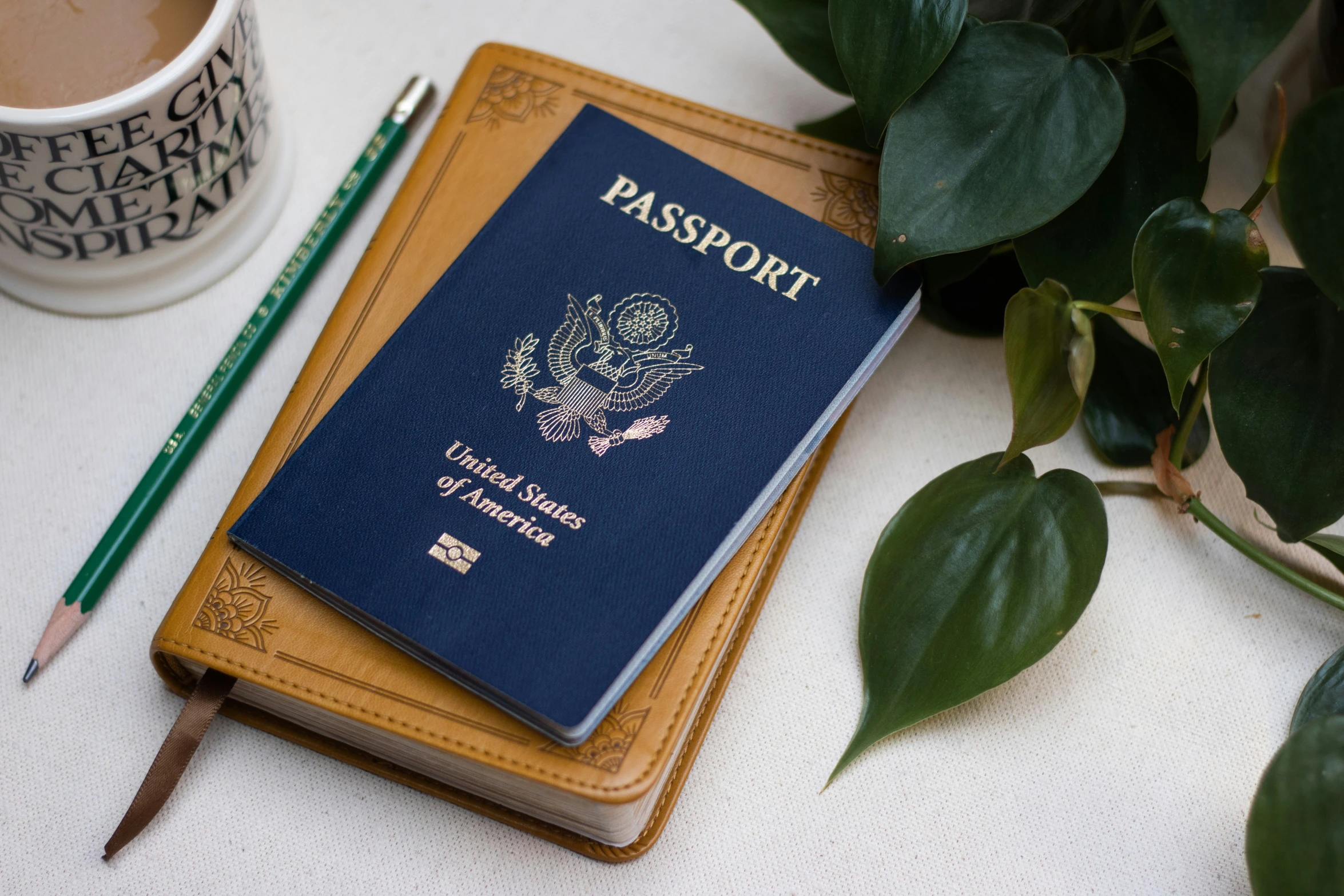 a blue passport sitting on top of a brown notebook