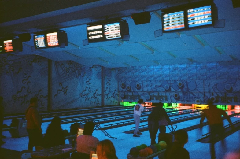 a room full of people bowling at neon lights