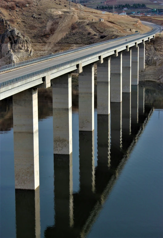 an empty bridge crossing over a river on a sunny day