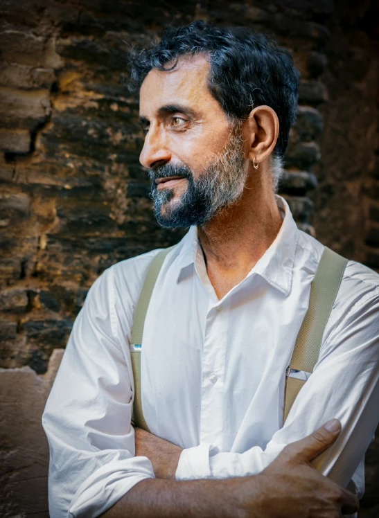 a man wearing a white shirt and suspenders posing for a po