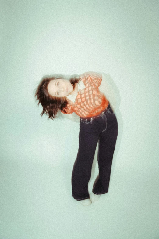 an aerial view of a girl wearing black pants and orange shirt