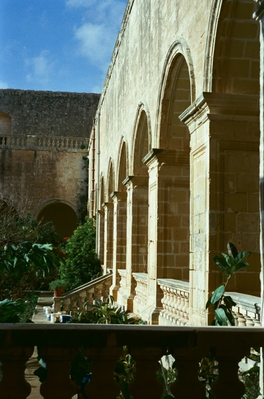 a building with two balconies and lots of plant life outside