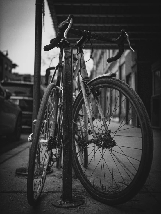 a black and white po of two bikes against a fence