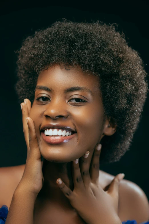 a woman smiles while holding her hands to her chest