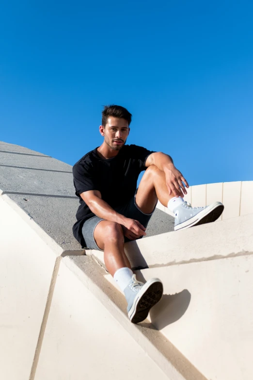 a man sitting on top of the side of a wall