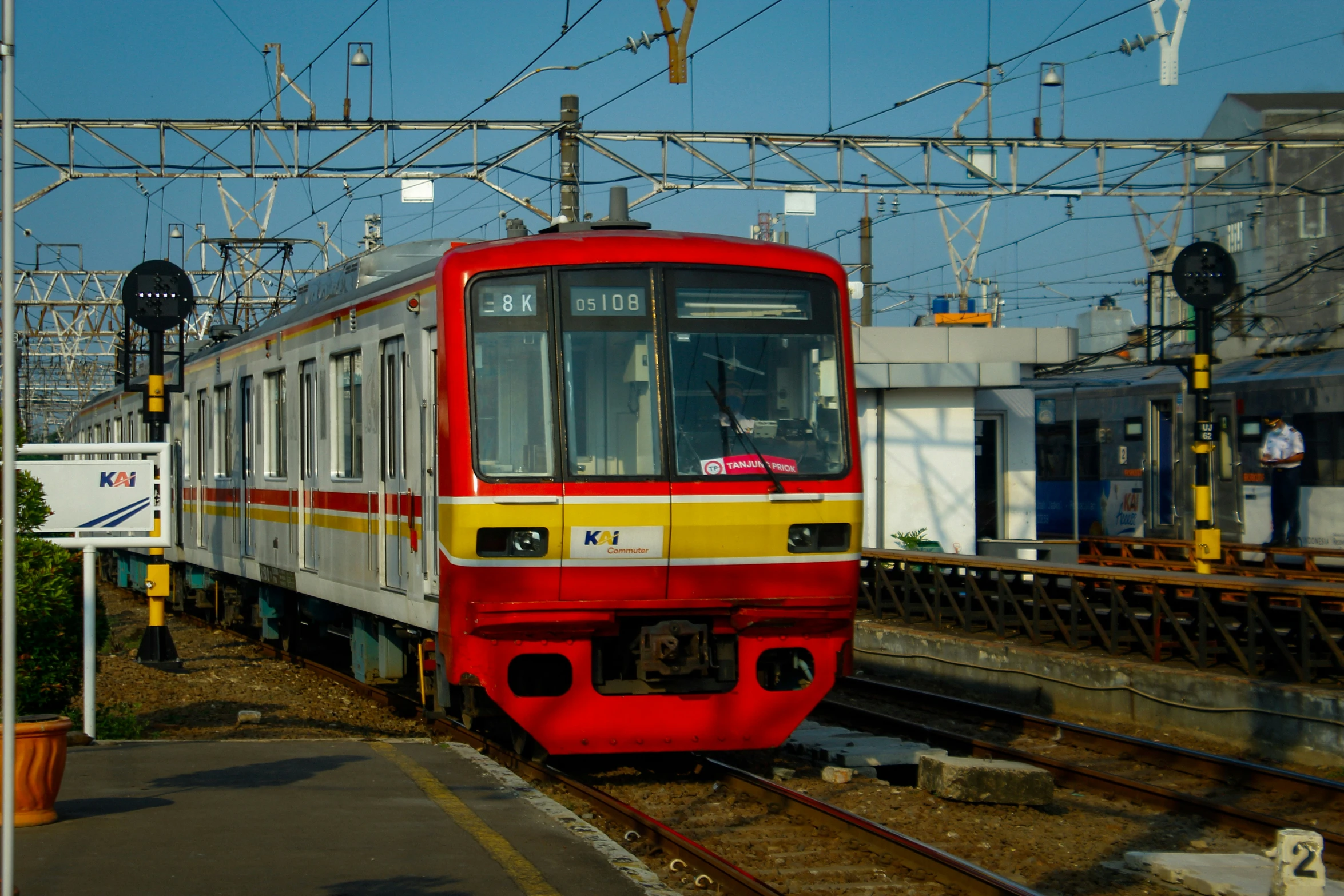 a red train traveling down tracks next to building