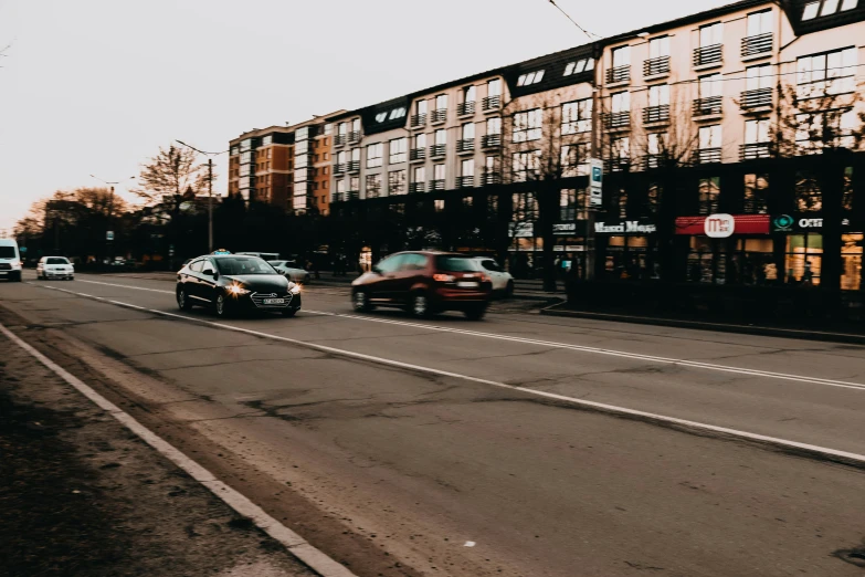 cars on the road are traveling down the street