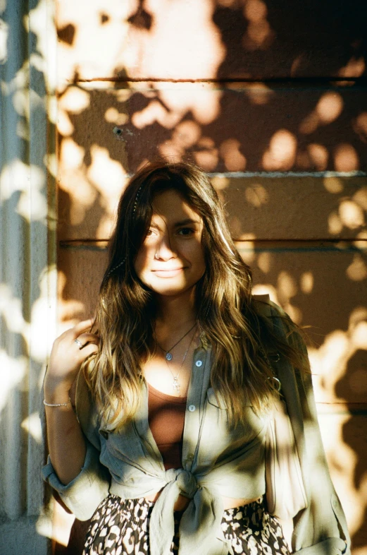 a woman in animal print pants posing by a wall