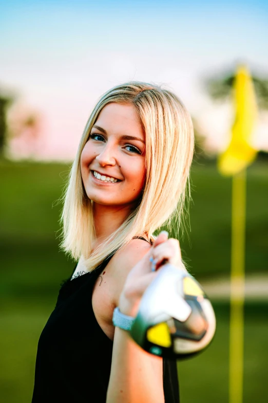 a pretty young blond woman holding a golf club