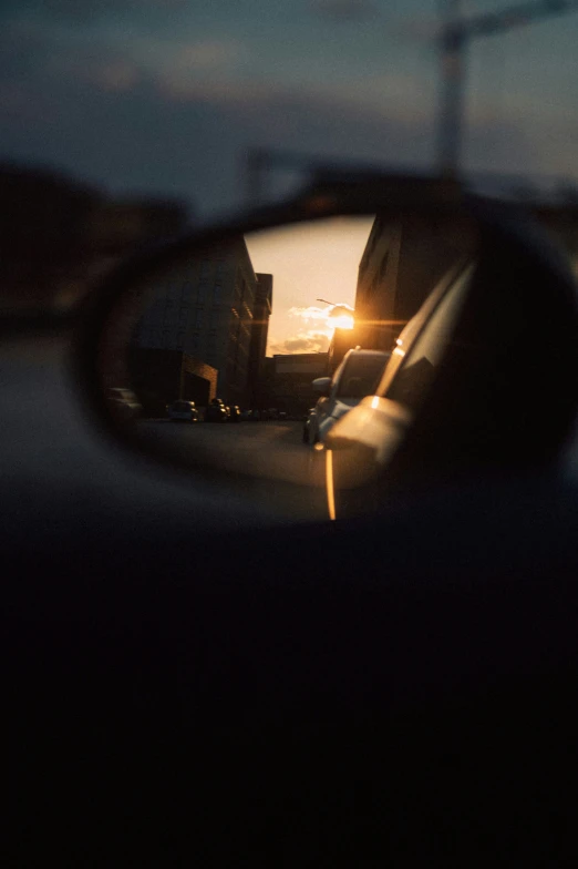 the rear view mirror of a car with some cars in it