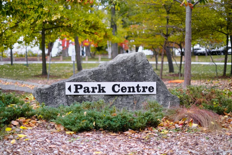 a park center sign sitting in the middle of a forest