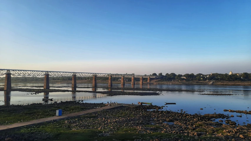 a river next to a bridge and bridge spanning it