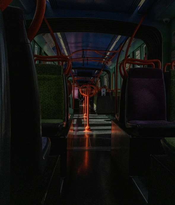 a dark lit po of two empty buses in a dimly lit area