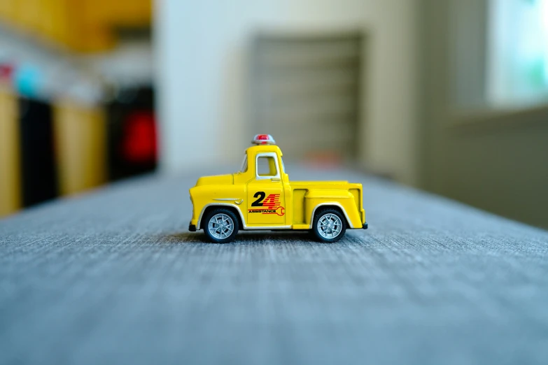 yellow truck with red light painted on top in close up