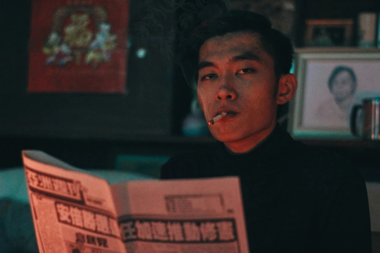 a young man looking through a newspaper at an image